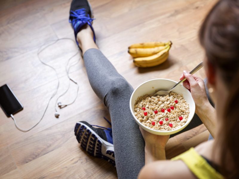 Frau isst Haferflocken mit Obst Sport