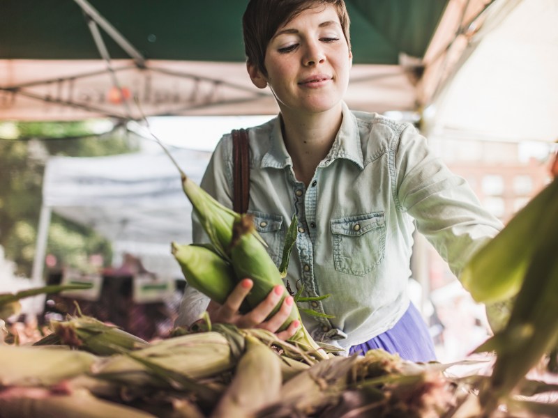 Frau kauft auf Wochenmarkt ein