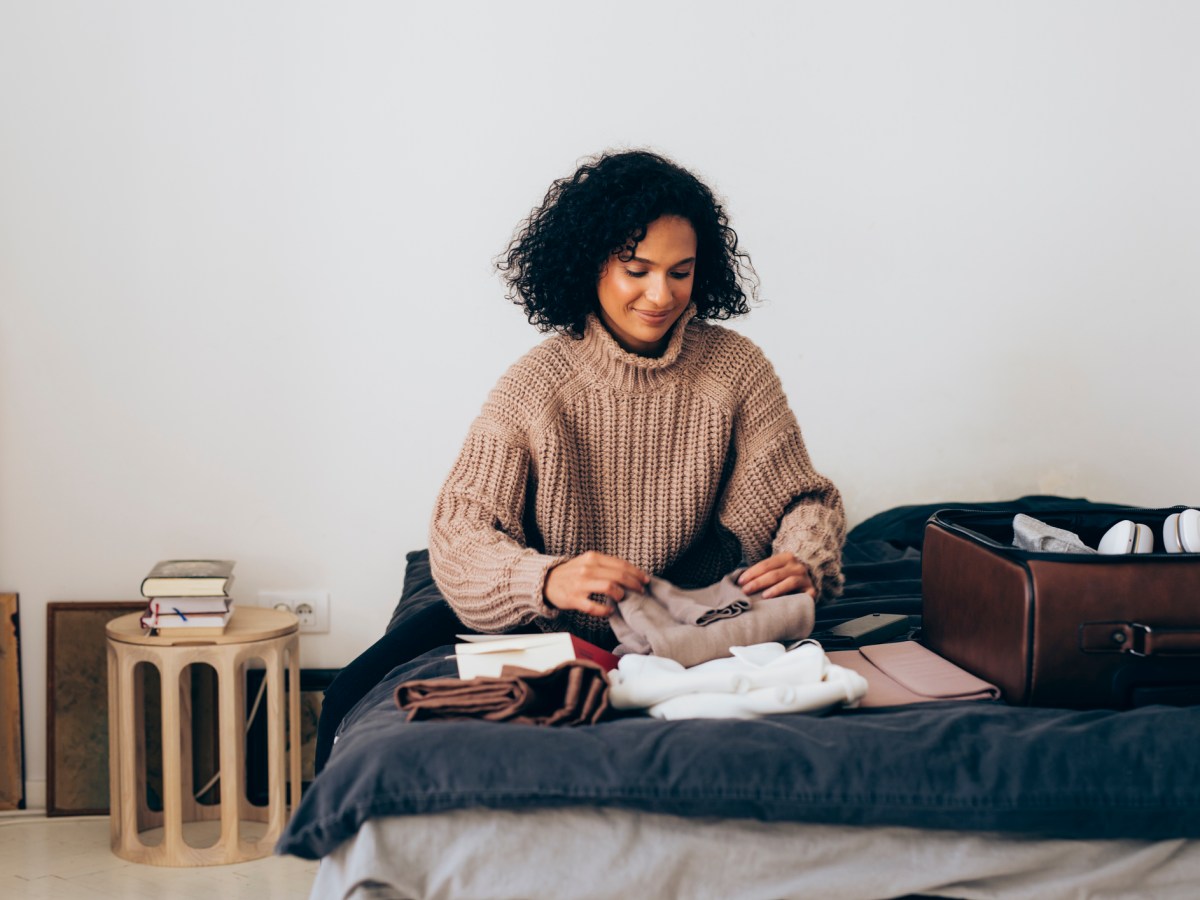 Frau am Koffer packen