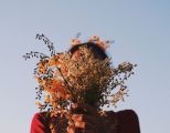 Frau mit Blumen vor dem Gesicht