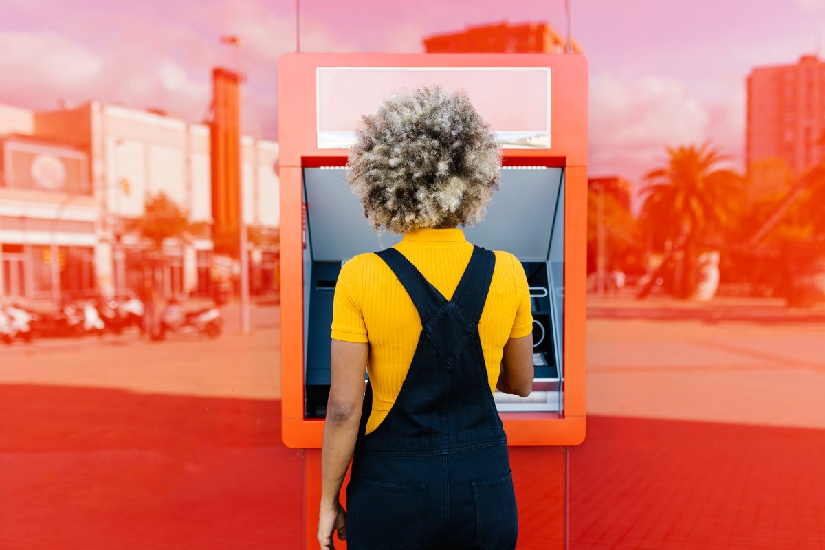 Eine Frau steht am Geldautomaten