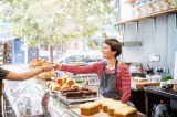 Frau verkauft in einer BÃ¤ckerei BrÃ¶tchen