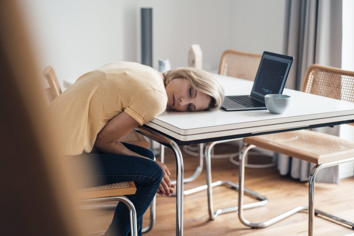 Frau schläft mit Kopf auf dem Tisch