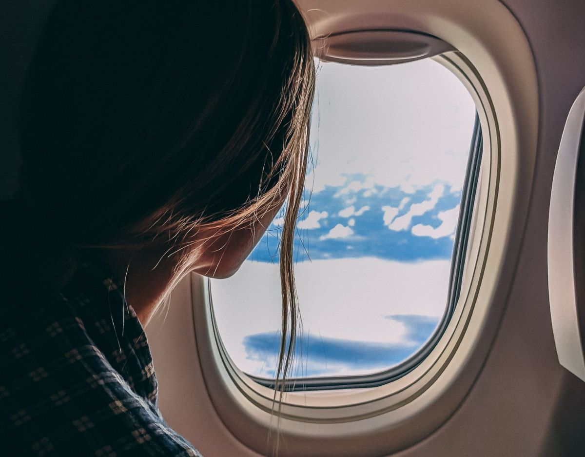 Frau blickt aus dem Fenster im Flugzeug