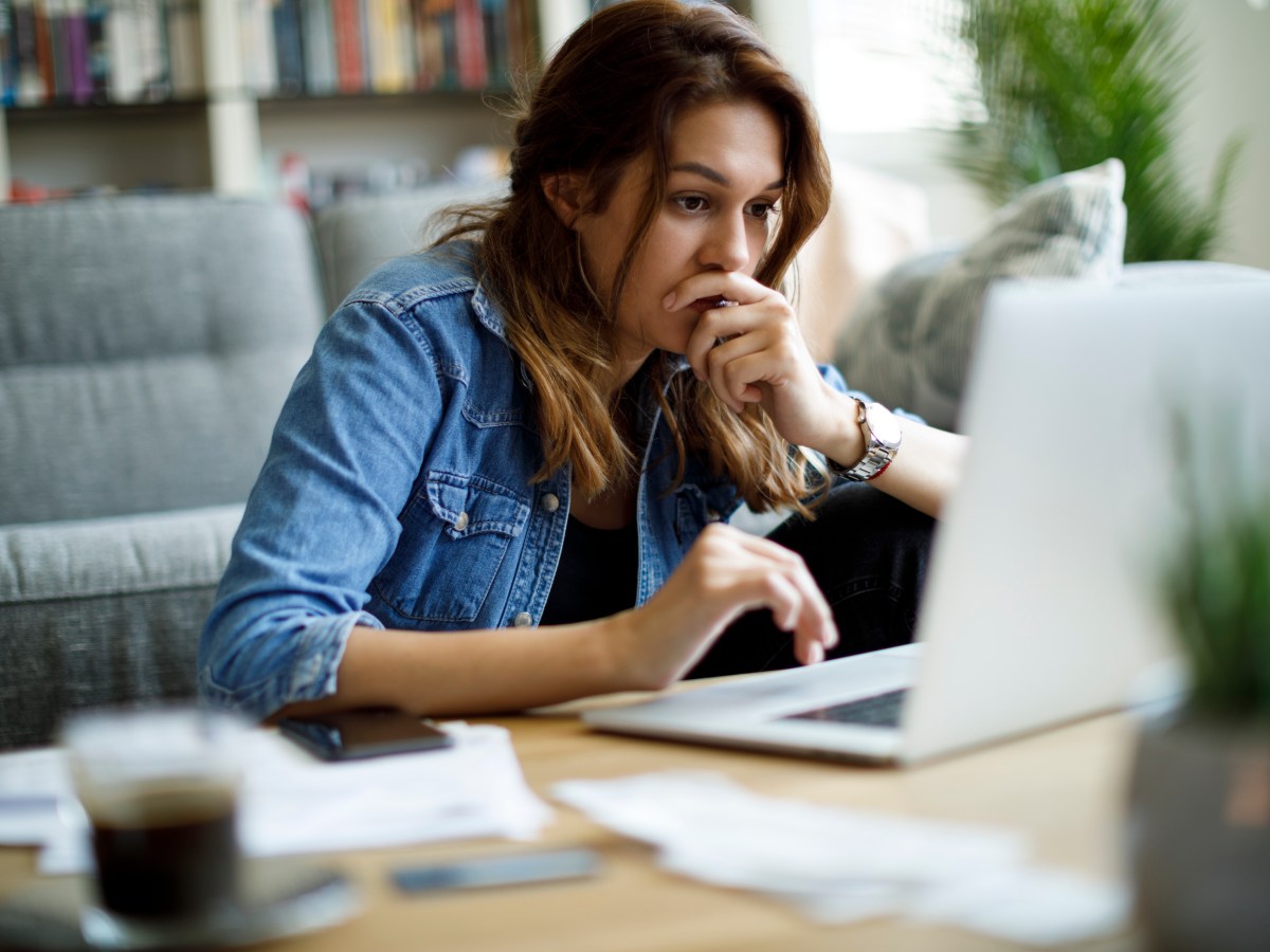 Frau sitzt konzentriert vor dem Laptop.