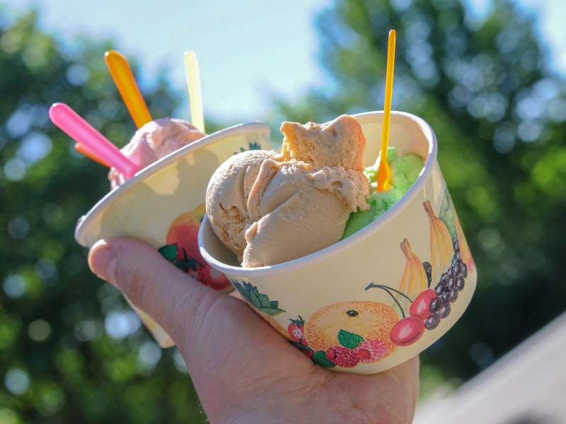 Eine Person hält zwei Becher mit Eis in der Hand.