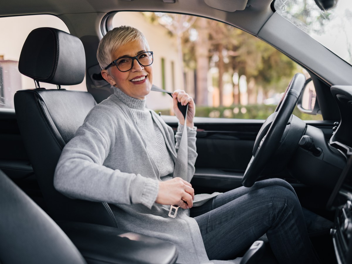 Eine Ã¤ltere Dame sitzt im Auto.