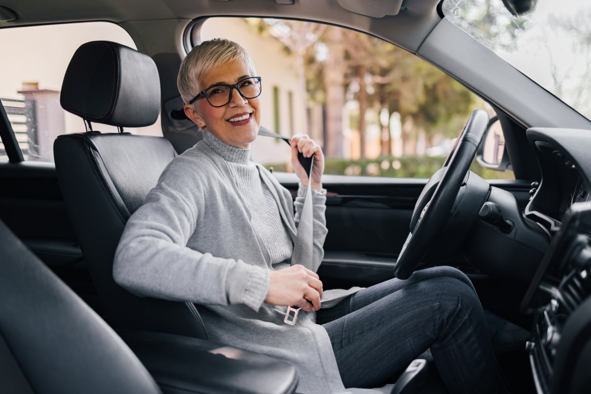 Eine ältere Dame sitzt im Auto.