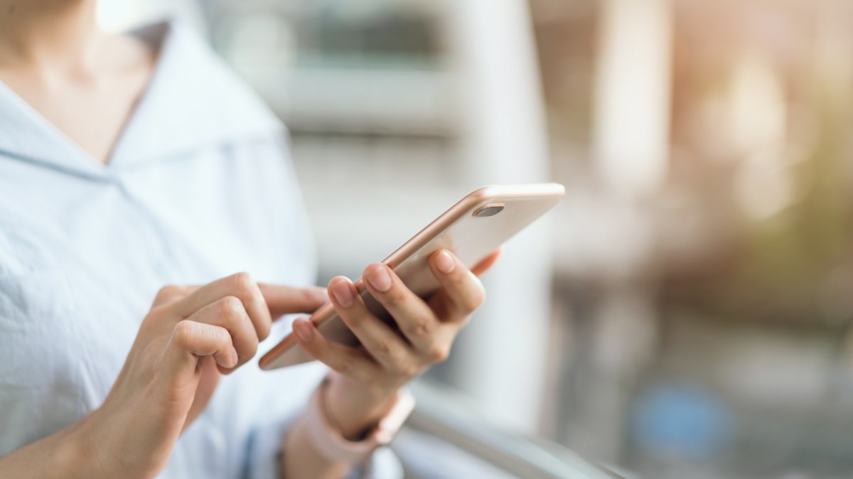 Frau hält ein Handy in der Hand.