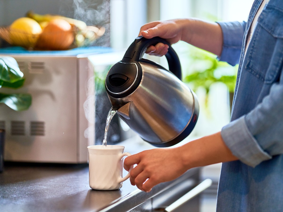 Person schÃ¼ttet sich warmes Wasser in die Tasse.