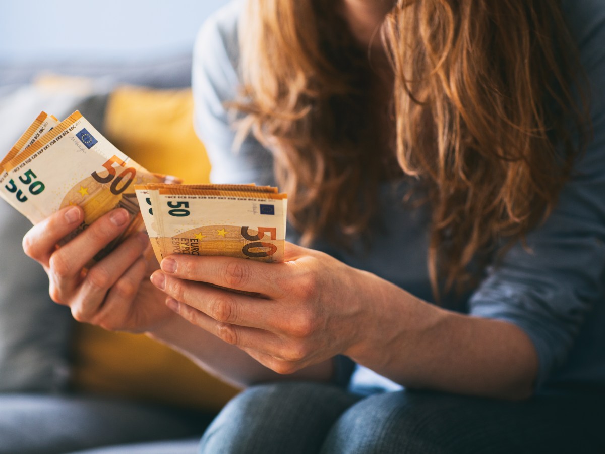 Ein Frau hält mehrere 50-Euro-Scheine in der Hand.