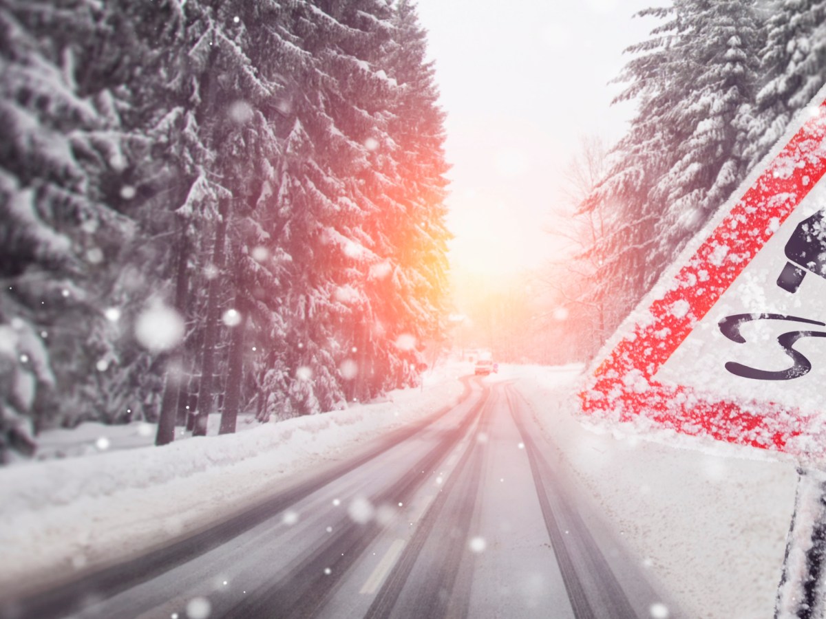 Eine StraÃŸe voller Schnee. Daneben steht ein Warnschild.