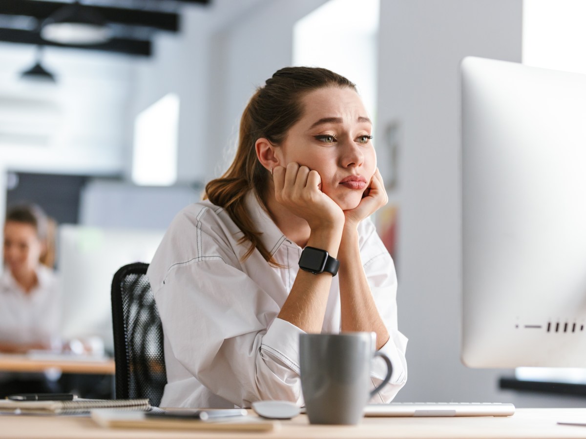 Eine Frau sitzt im BÃ¼ro vor ihrem Computer und langweilig sich.