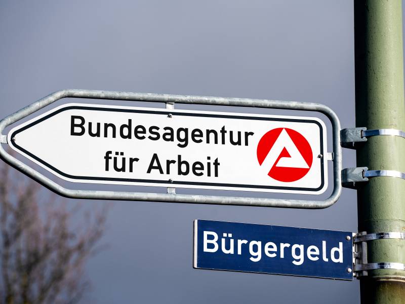 Unter einem Schild der Bundesagentur fÃ¼r Arbeit hÃ¤ngt ein weiteres Schild mit der Aufschrift 