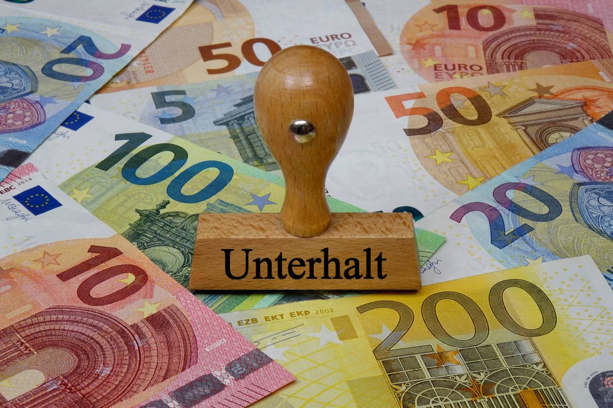 Ein Stempel mit der Aufschrift "Unterhalt". Darunter liegen Geldscheine.