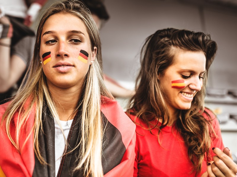 Frauen mit Fußball-Flaggen im Gesicht