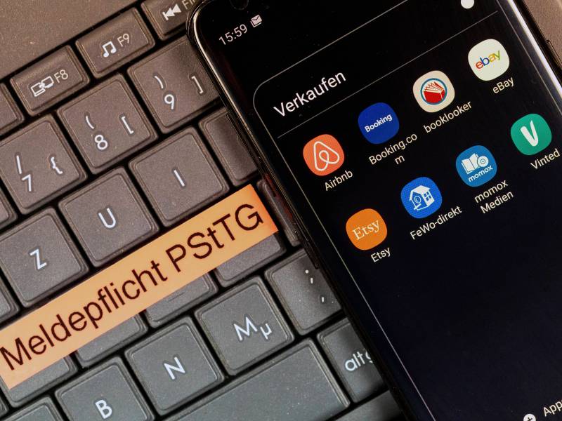 Eine Handy mit Online-Verkaufsplattformen liegt auf einer Tastatur.