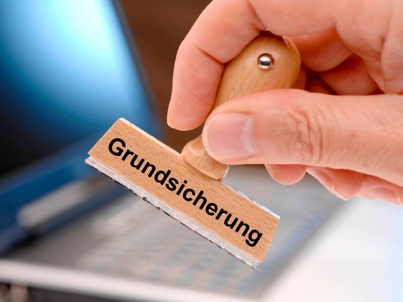 Auf einem Stempel steht das Wort "Grundsicherung".