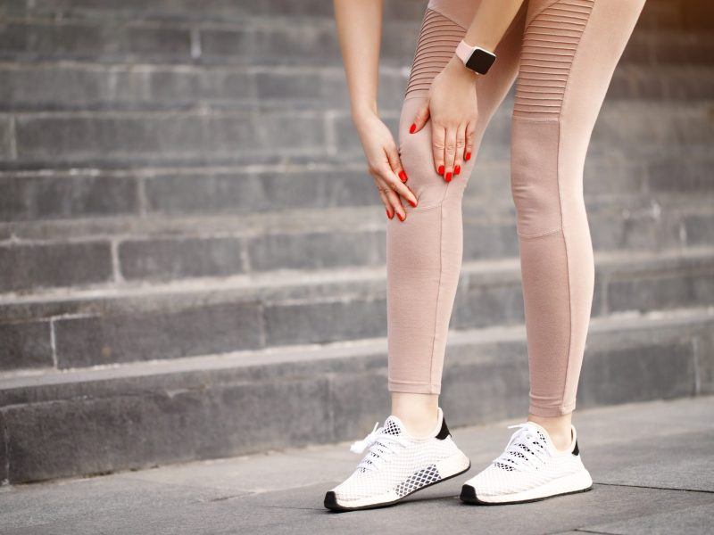 Frau hat Knieschmerzen beim Joggen