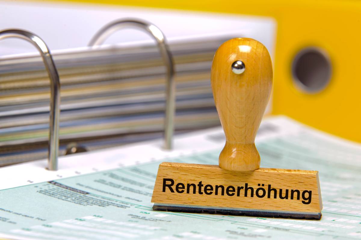 Auf einem Stempel steht das Wort "Rentenerhöhung". Darunter liegen Dokumente.