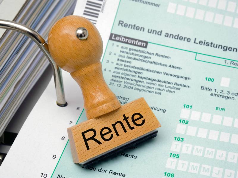 Auf einem Stempel steht das Wort "Rente". Darunter liegt ein Dokument.