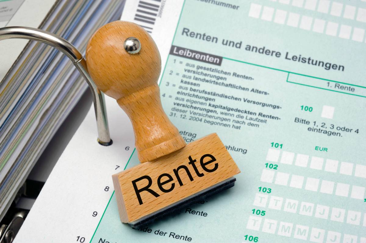 Auf einem Stempel steht das Wort "Rente". Darunter liegt ein Dokument.