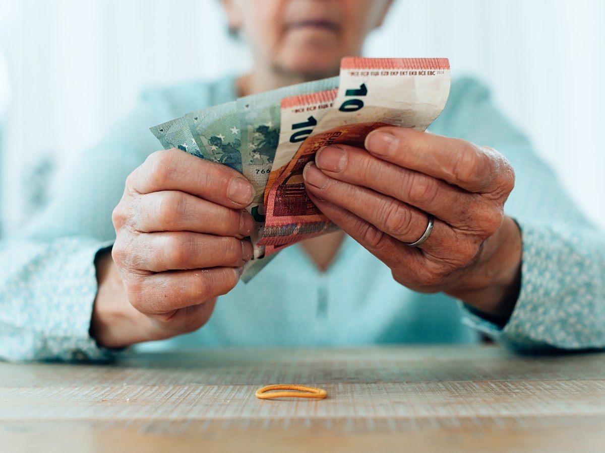 Eine Seniorin hÃ¤lt Geldscheine in der Hand.