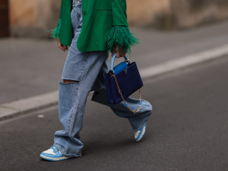 Frau geht in Jeans über Straße