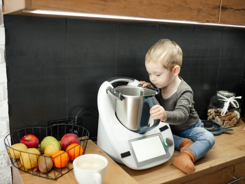 Kind sitzt neben Thermomix