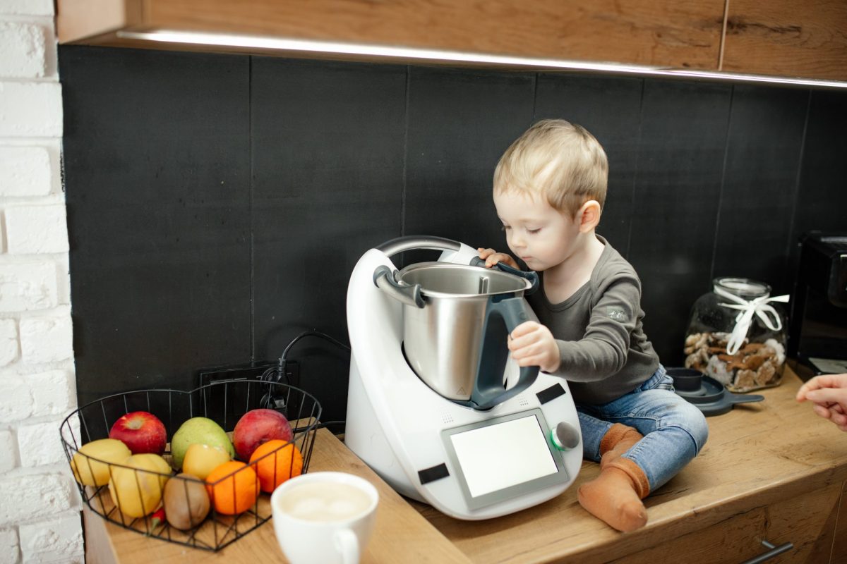 Kind sitzt neben Thermomix