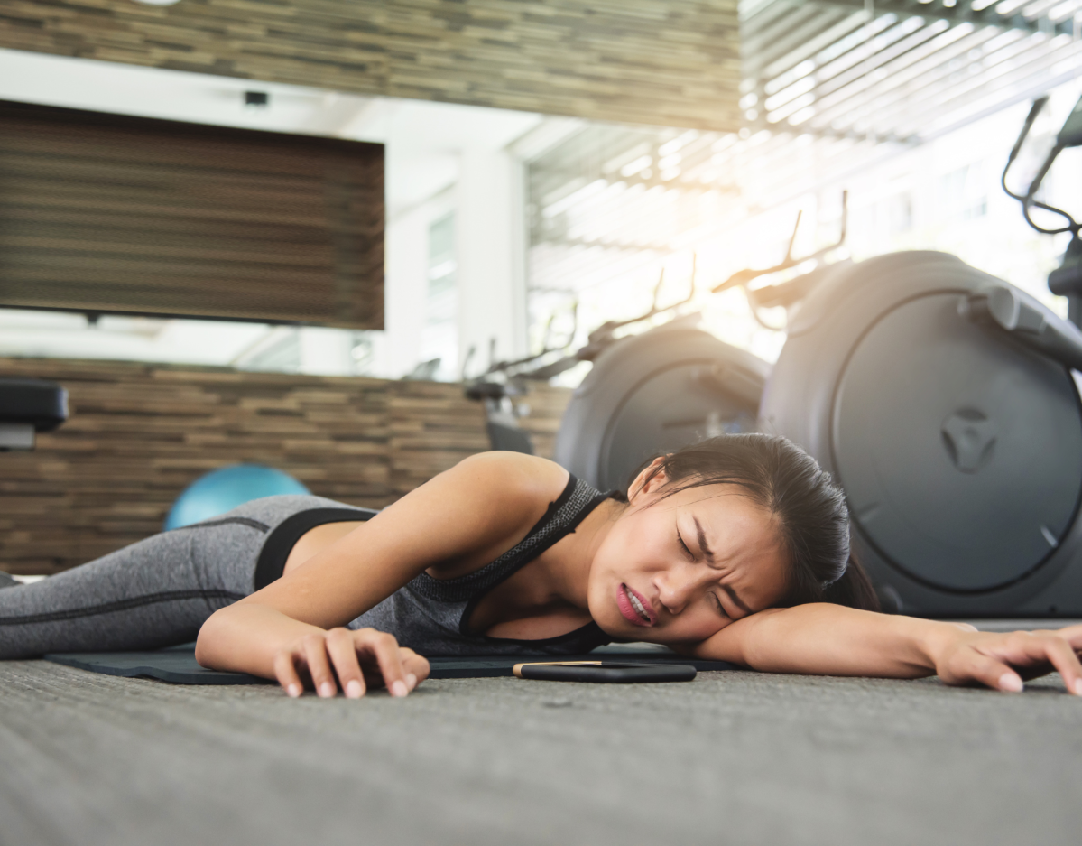 Frau liegt auf dem Boden im Fitnessstudio