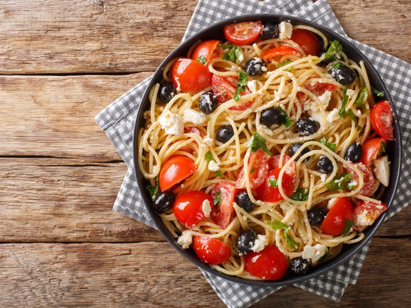 Spaghettisalat mit Feta und Tomaten in einer SchÃ¼ssel.