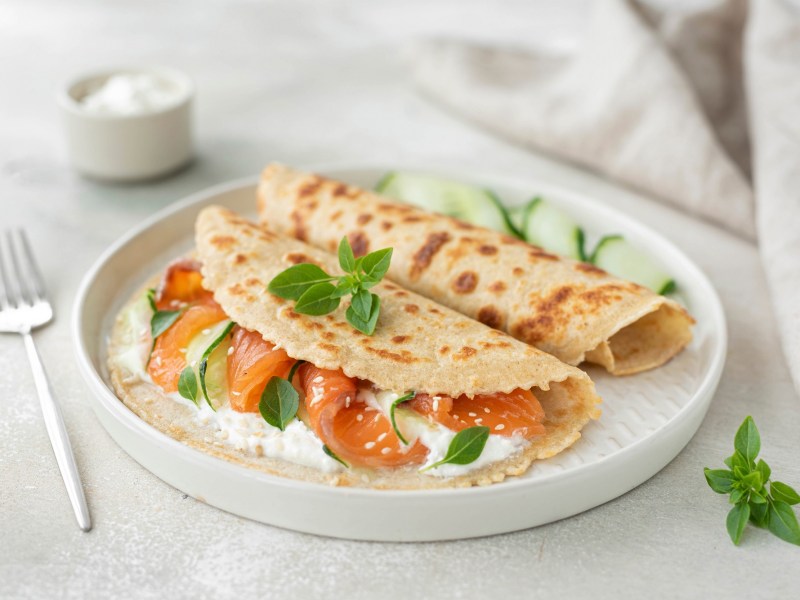 Haferflocken-Pfannkuchen belegt mit Lachs und FrischkÃ¤se auf einem Teller.