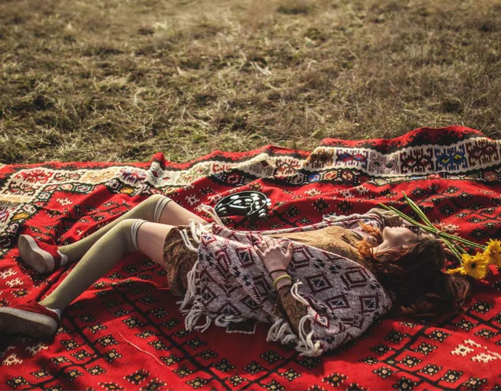 Lagom: Eine Frau liegt auf einer Decke auf der Wiese.