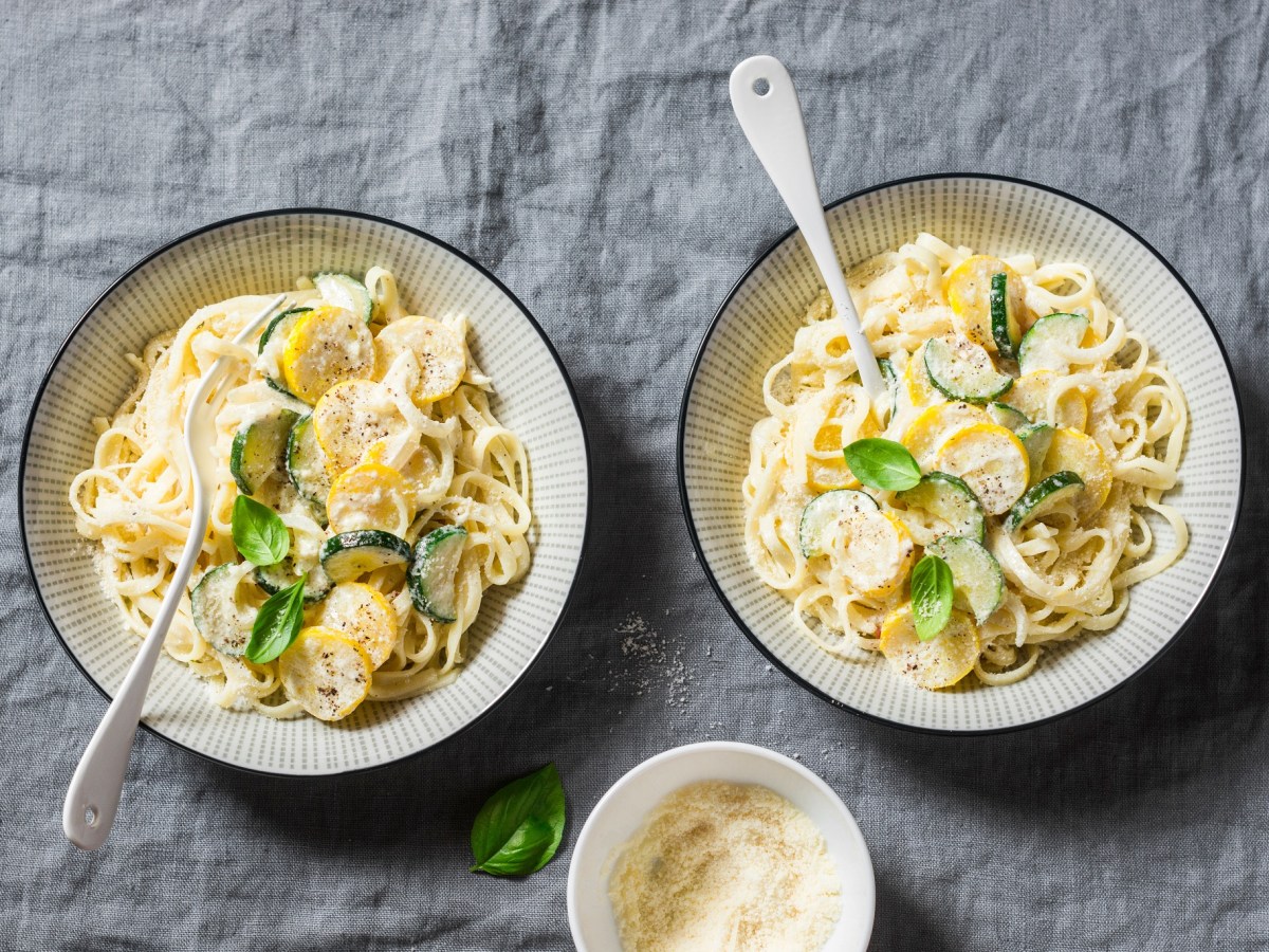 Zwei Teller Nudeln mit Zucchini-FrischkÃ¤se-SoÃŸe.