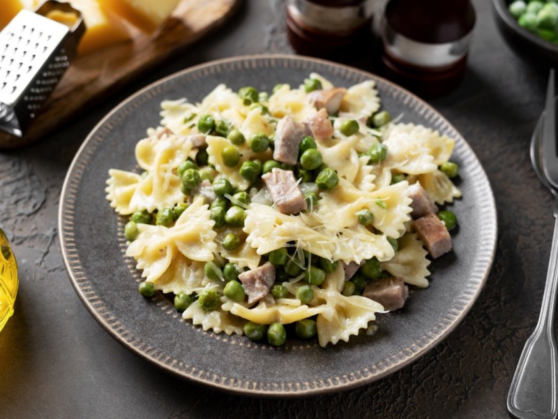 Ein Teller mit Pasta à la Chef. Daneben liegen Besteck und Zutaten.