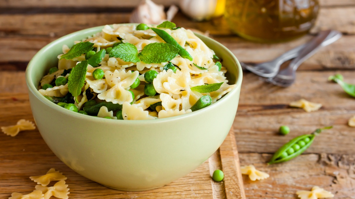 Pfefferminz-Farfalle in grÃ¼ner SchÃ¼ssel auf Holztisch.