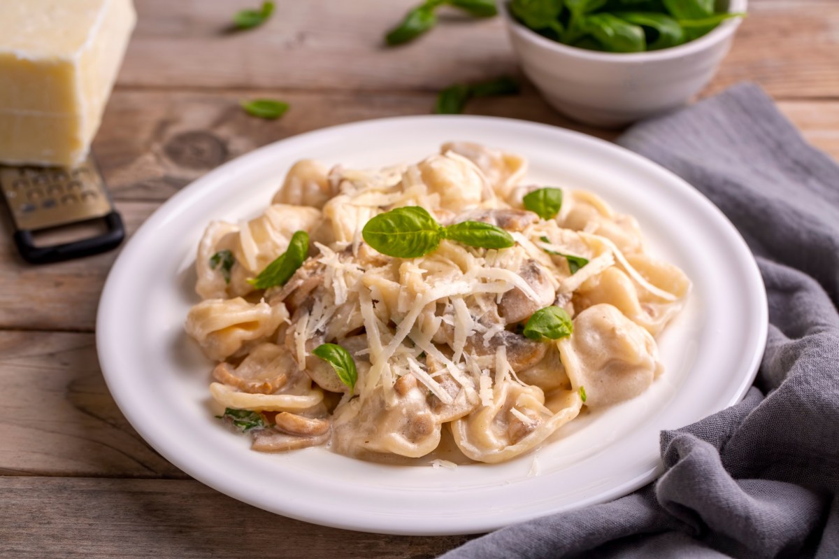 Tortellini in PilzsoÃŸe auf einem Teller.