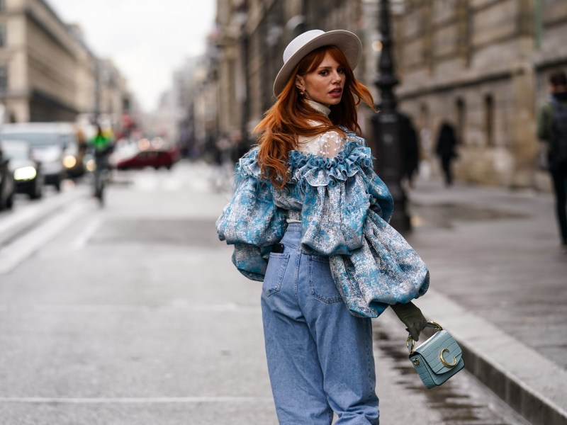 Frau in RÃ¼schenbluse und Jeans auf StraÃŸe