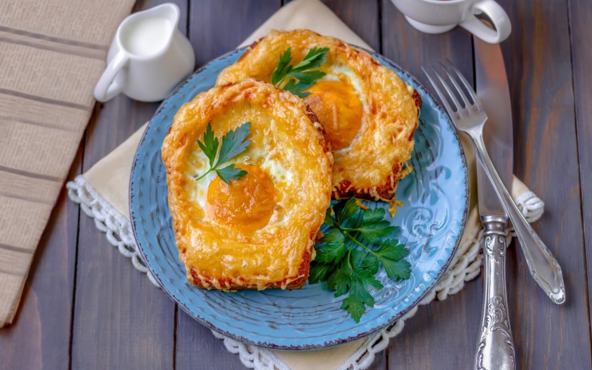 Zwei Spiegelei-Toasts auf einem blauen Teller.