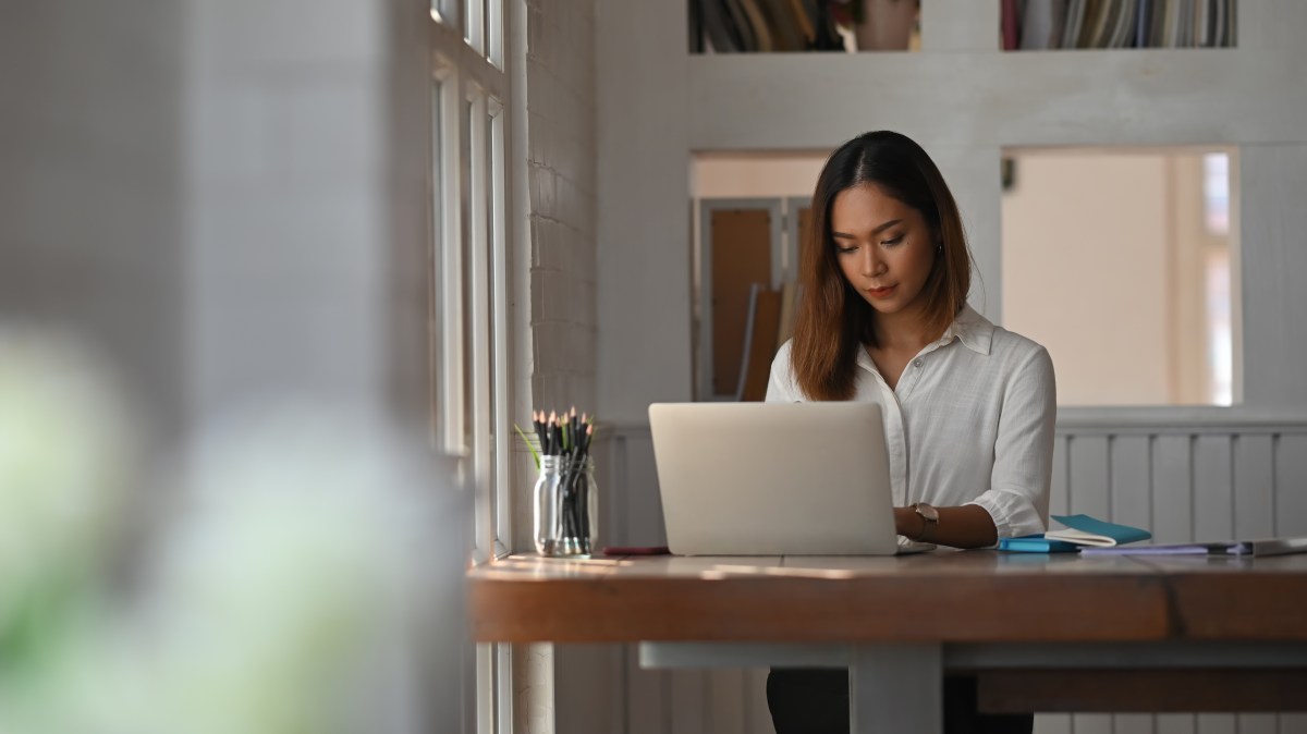 Geschäftsfrau arbeitet im Homeoffice mit Laptop-Computer.