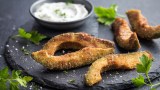 Frittierte Avocado auf schwarzem Teller mit KrÃ¤uter-Dip.