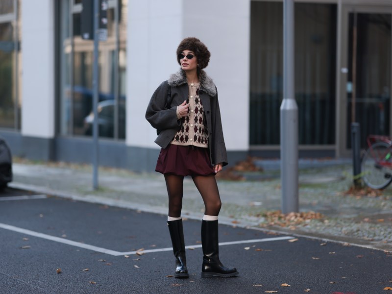 Frau trÃ¤gt Rock mit flachen Boots