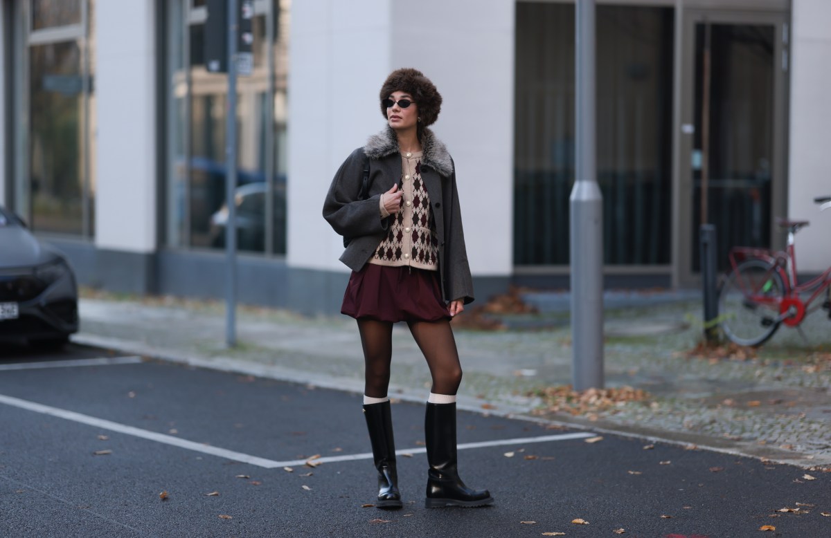 Frau trÃ¤gt Rock mit flachen Boots