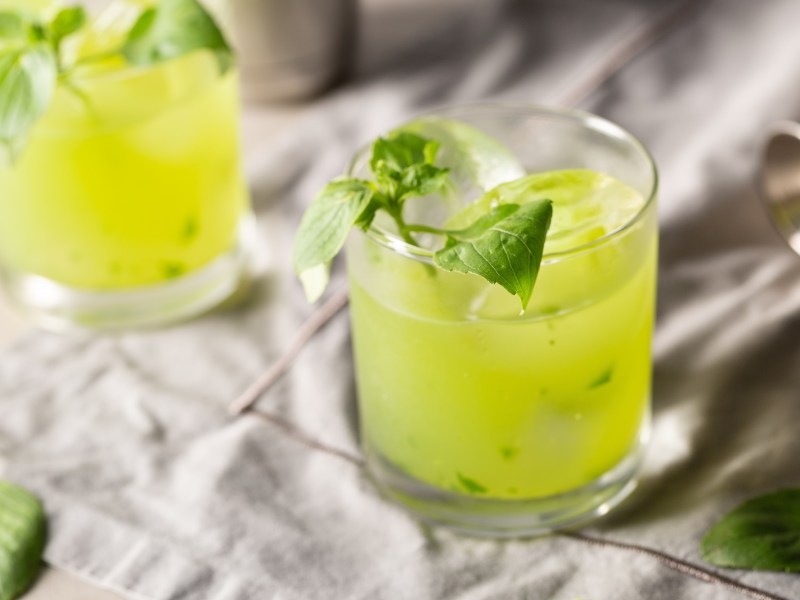 Zwei GlÃ¤ser Gin Basil Smash auf grauem Untergrund