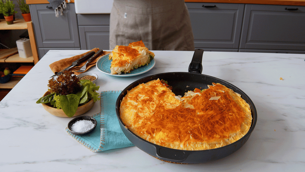 Eine herbstliche BÃ¶rek-Pfanne mit KÃ¼rbis und Yufka-Teig auf einer KÃ¼chentheke, daneben eine Schale Salz und ein Teller mit einem StÃ¼ck des Auflaufes.