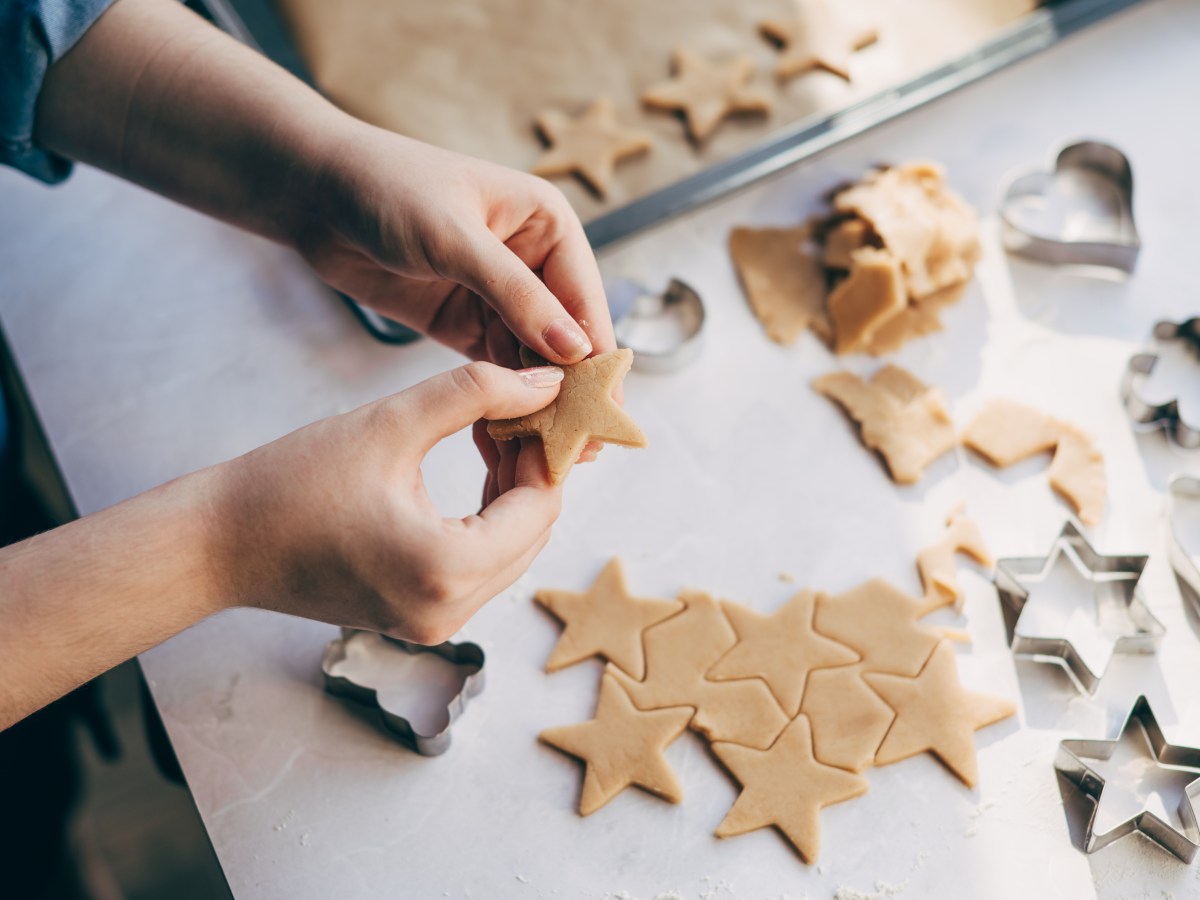 Junge Frau bereitet WeihnachtsplÃ¤tzchen auf dem Tisch zu.