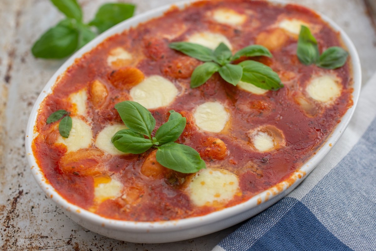 Gnocchi alla sorrentina: Ã¼berbackene Gnocchi mit TomatensoÃŸe und Mozzarella in einer Auflaufform, garniert mit Basilikum.