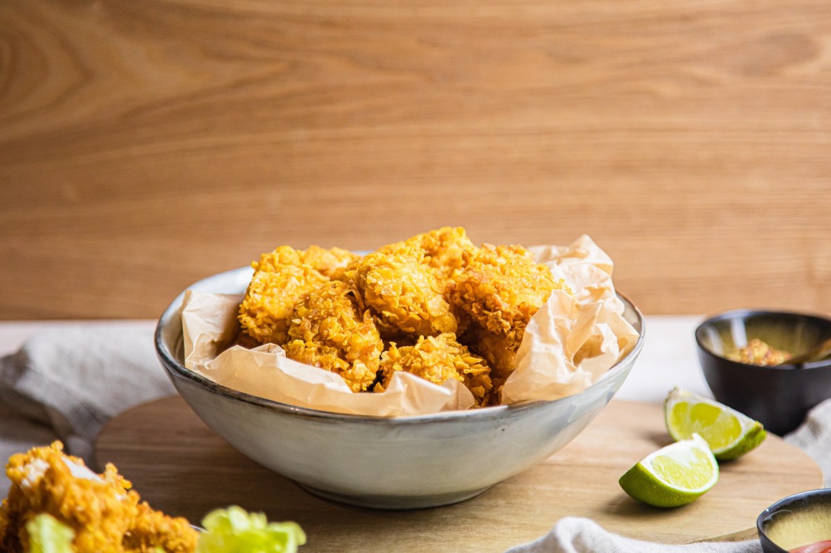 Eine Schale vegane Chicken Nuggets, daneben Limettenspalten.