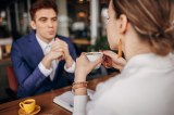 Kaffeetassen-Test: GeschÃ¤ftsmann, der mit einer Frau ein GesprÃ¤ch fÃ¼hrt. Sie trinkt einen Kaffee.